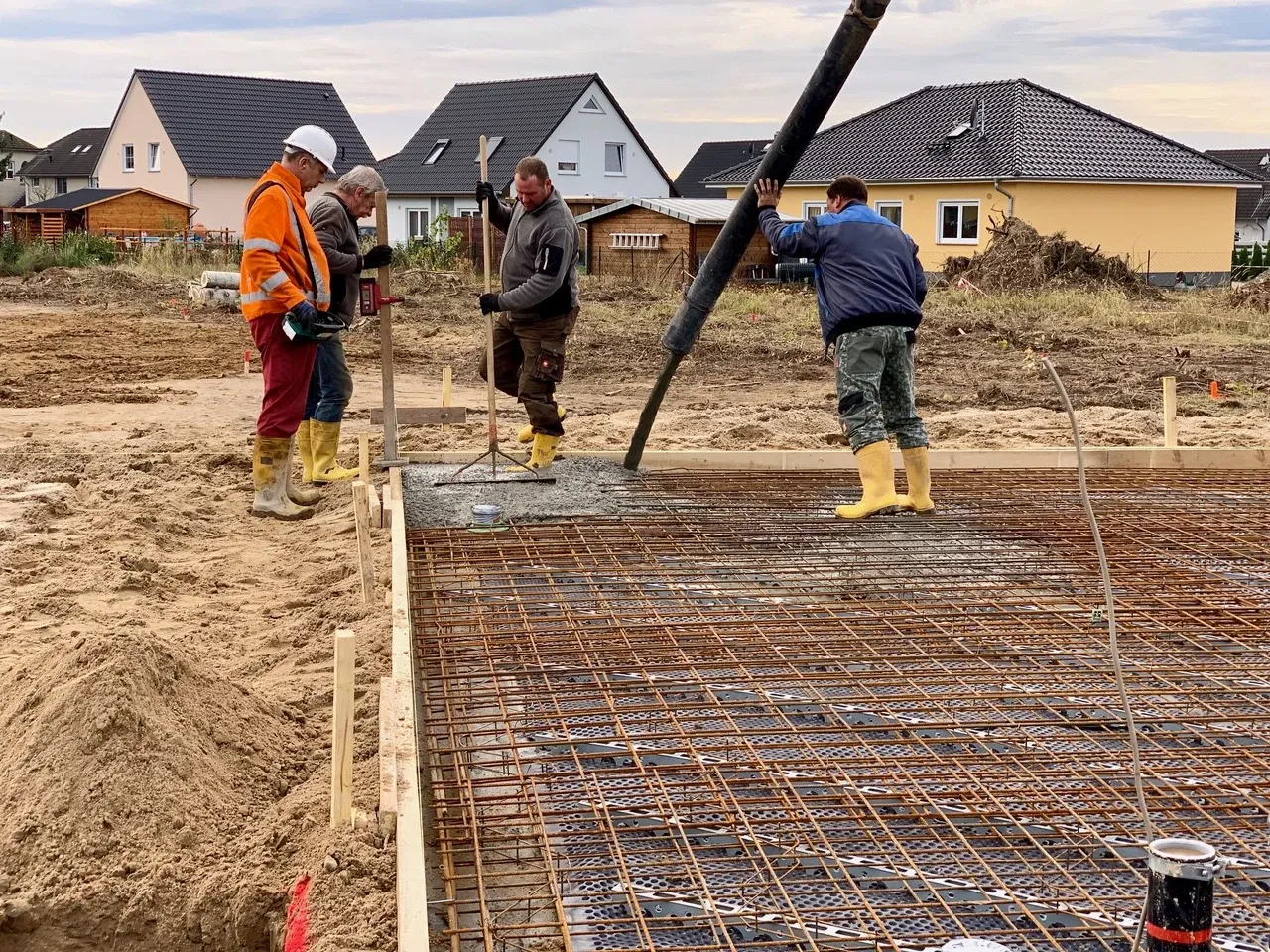 Bauarbeiter beim Betonieren der Bodenplatte des Einfamilienhauses in Mittenwalde/Ragow