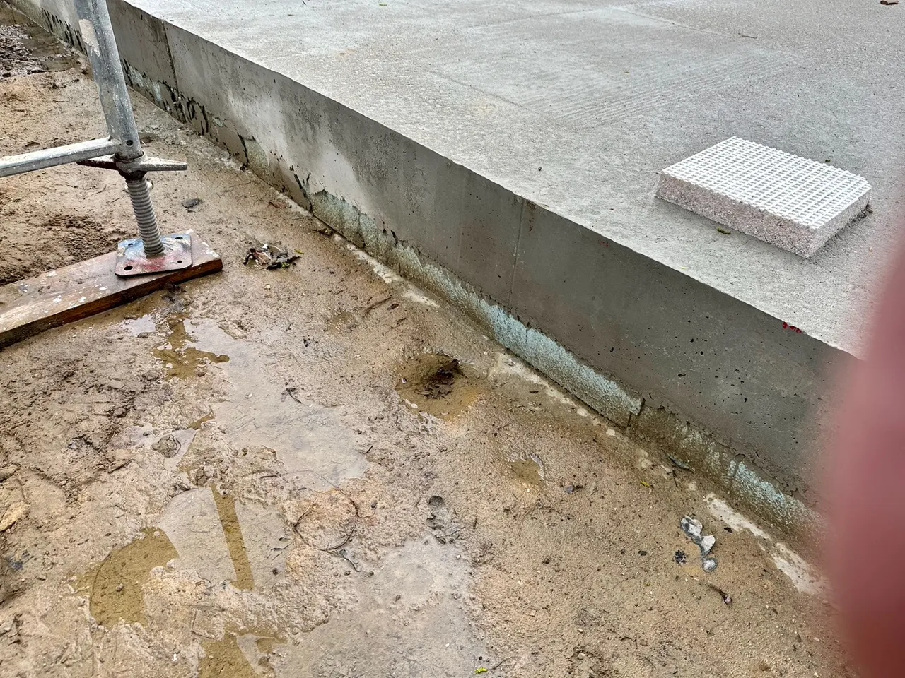 Fertig betonierte Bodenplatte mit Sockel und sichtbarem Dämmstreifen am Übergang zum Erdreich — Ergebnis einer fachgerecht geplanten und ausgeführten Bohrpfahlgründung beim Einfamilienhaus in Berlin-Rahnsdorf