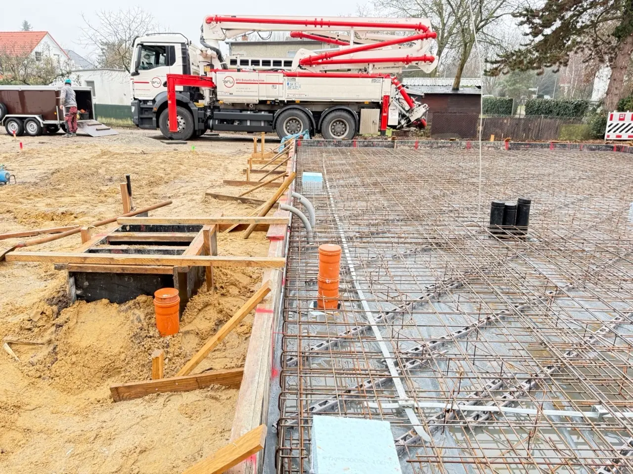 Bewehrte Bodenplatte auf der Baustelle in Berlin-Biesdorf mit Betonpumpe beim Einbringen des Betons