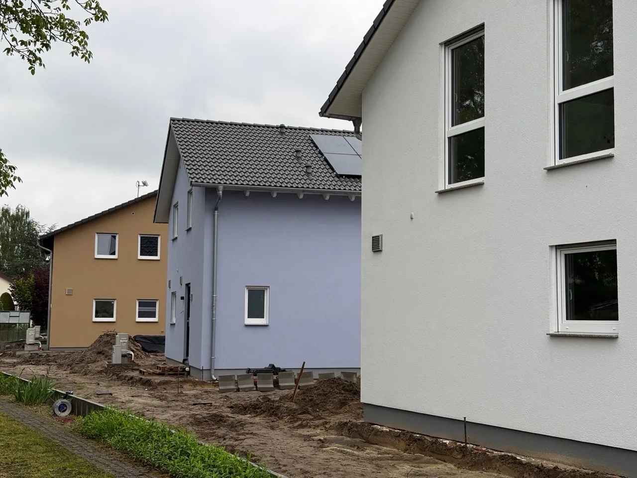 Fertiggestellte Einfamilienhäuser in Berlin-Biesdorf ohne Baugerüst, eines davon mit Photovoltaikanlage auf dem Dach