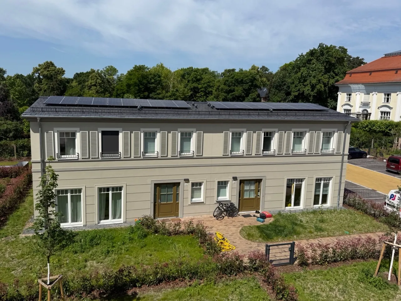 Fassade eines Mehrfamilienhauses im Quartier TIAMO Potsdam mit Photovoltaikanlage auf dem Dach